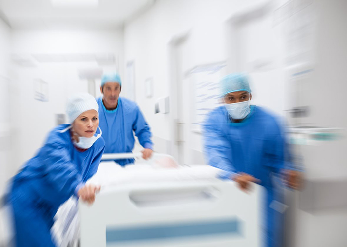 Team of doctors rushing a patient into a hospital ER after testing troponin levels