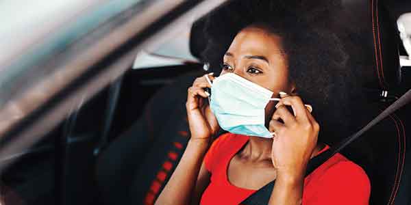 Woman puts on face mask to help protect from SARS-CoV-2