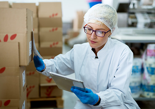 Laboratory supervisor performing manual inventory counting boxes with a laboratory inventory management system