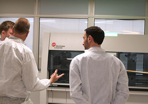Laboratorians looking at a Beckman Coulter DxA 5000 Total Lab Automation System