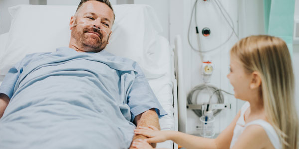 Man in hospital bed with daughter