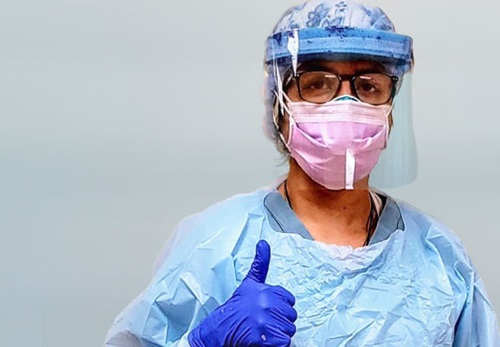 Front line care worker in scrubs an protective mask